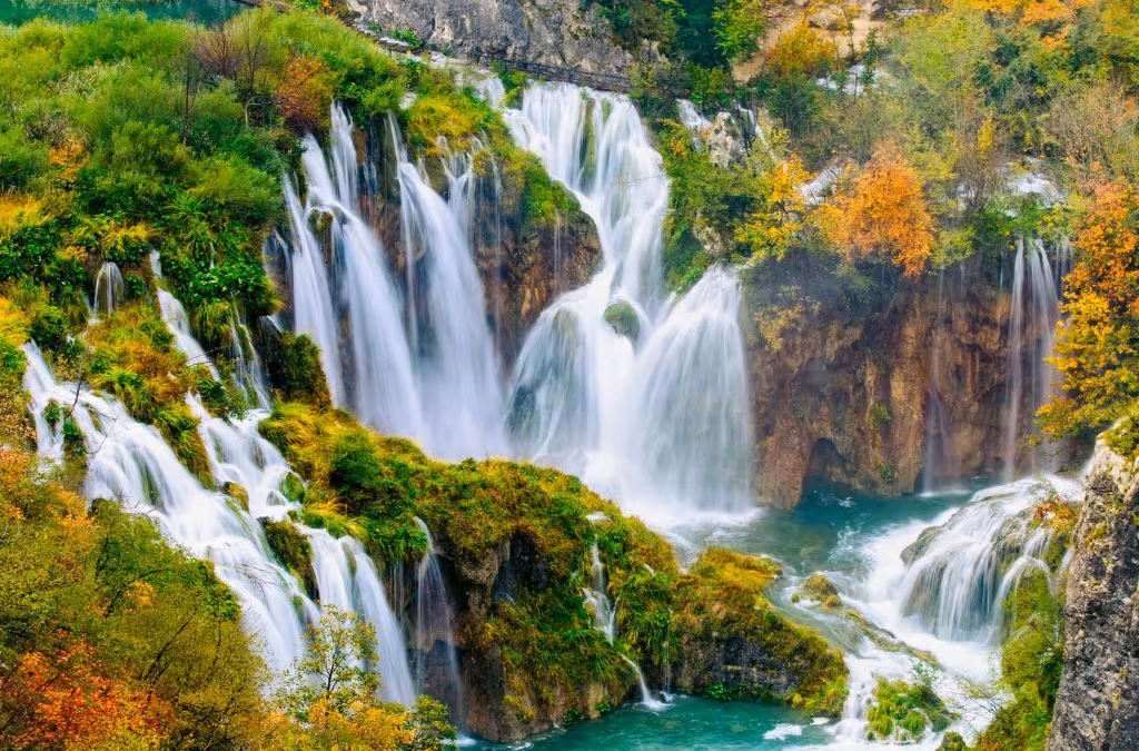 Croatian waterfall surrounded by forested karst canyon.