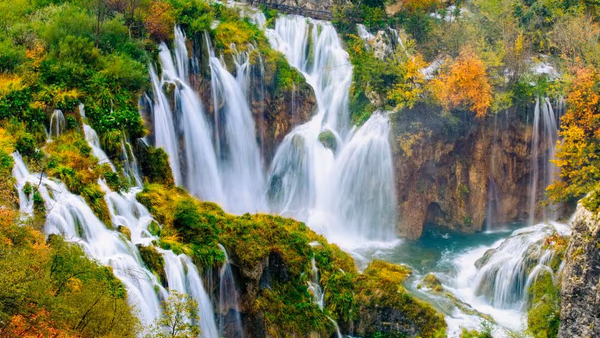 Croatian waterfall surrounded by forested karst canyon.