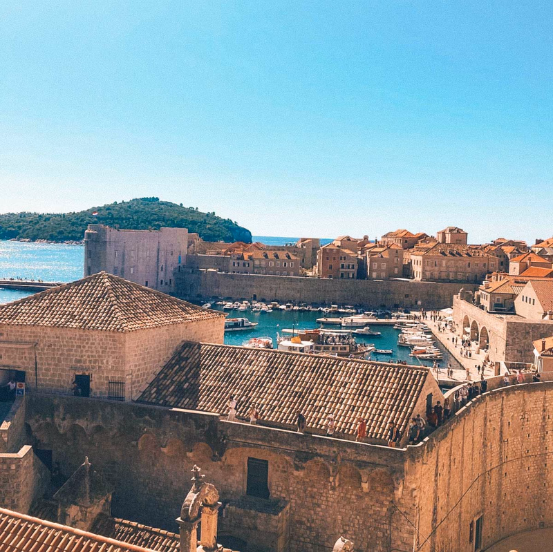 Dubrovnik Old Port and City Walls with boats and fortifications under a clear sky