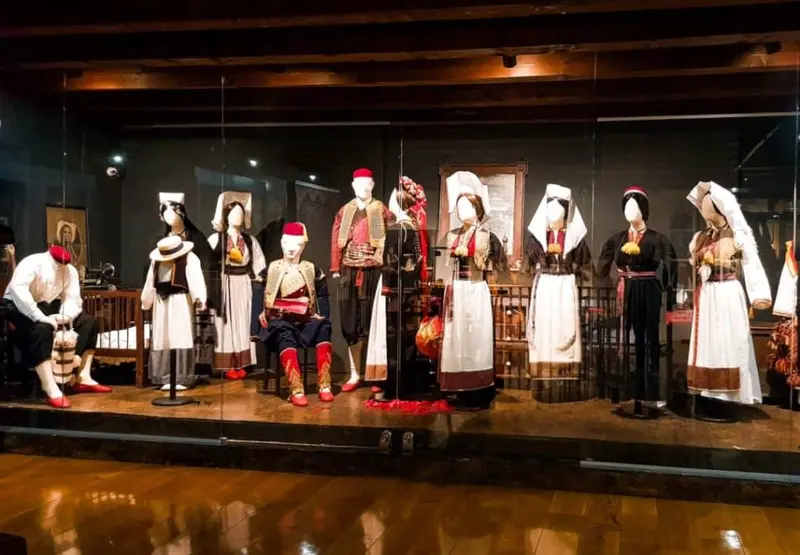 Konavle folk costumes, embroideries, and textiles in glass cases.