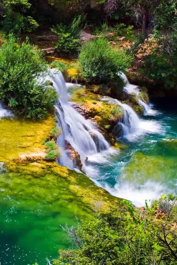 Close view of Roški Slap's travertine ledges and green water.