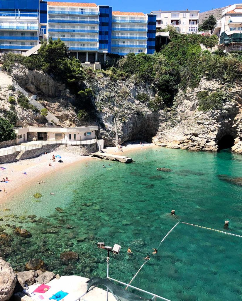 Photo of Bellevue, a small pebbly beach in a cliff-surrounded bay.