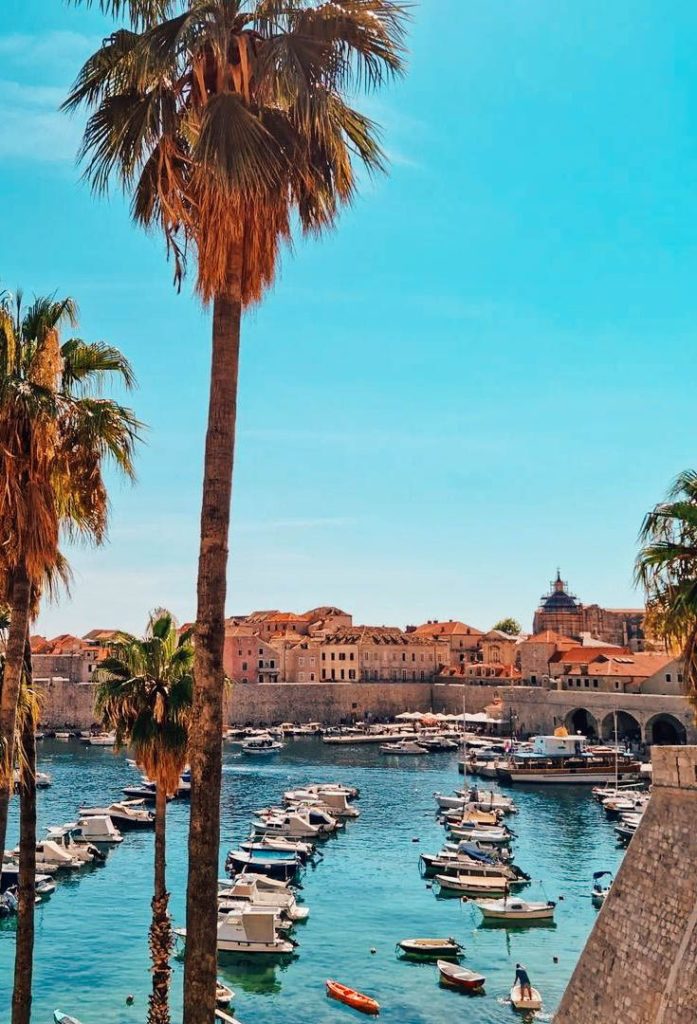 Dubrovnik Old Port with small boats and the cathedral in the background.