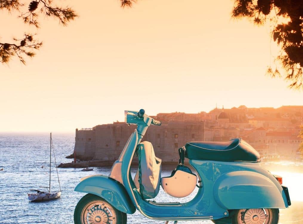Vespa Scooter in front of Dubrovnik Old Town at sunset